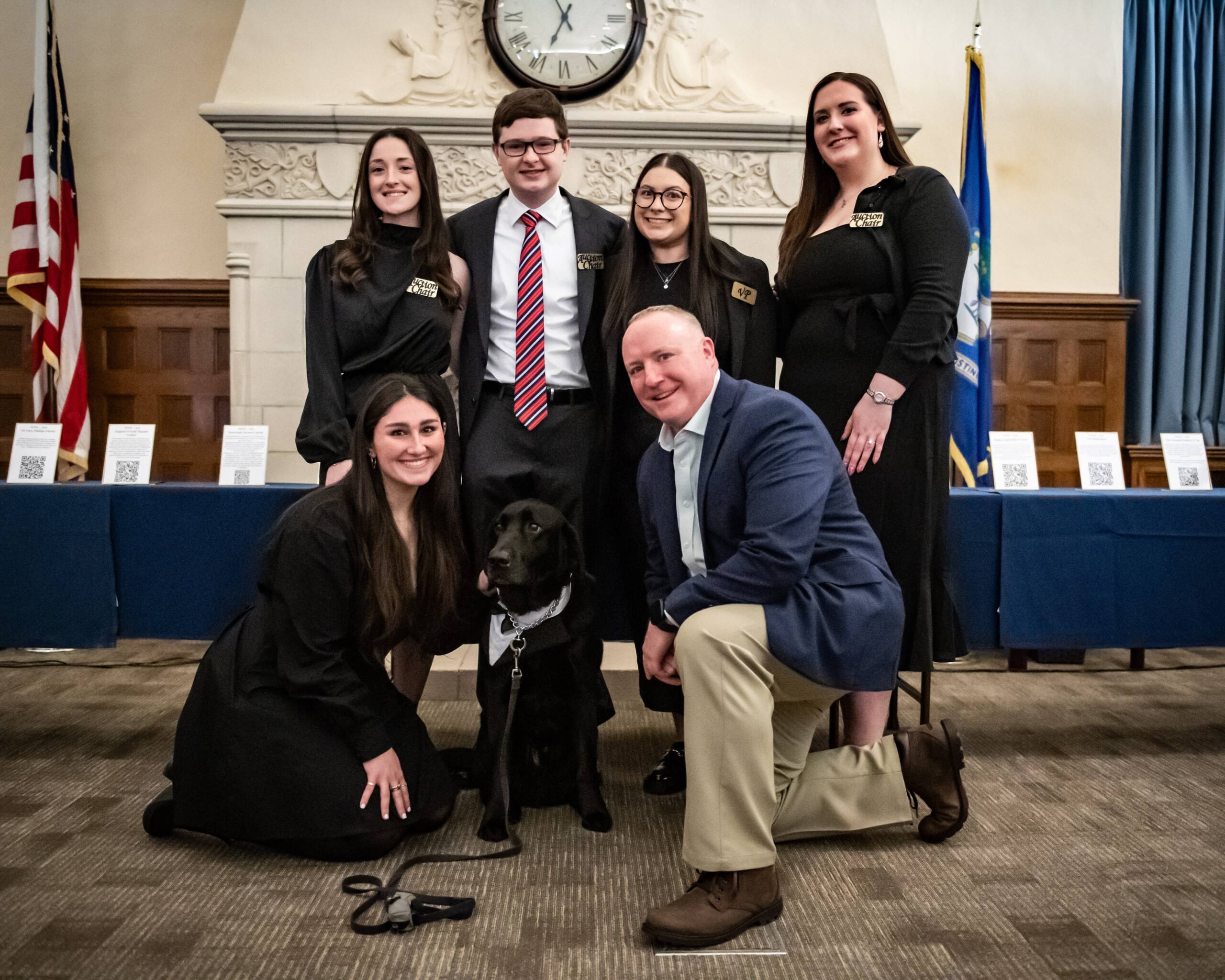 A group of law student posing at the annual PILG auction alongside Officer Carson