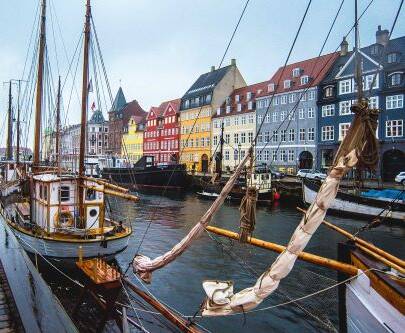 Copenhagen Harbor featuring brightly colored buildings alongside a river with sailboats